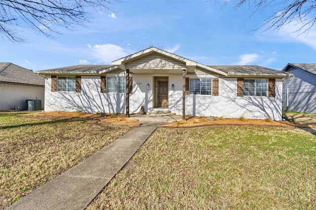 single story home with a front lawn, central air condition unit, and brick siding