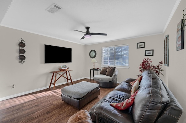 living room featuring visible vents, crown molding, baseboards, ceiling fan, and wood finished floors
