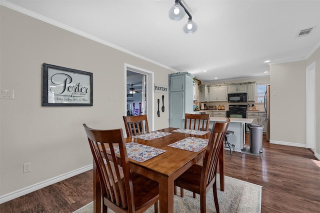 dining room featuring crown molding, baseboards, visible vents, and dark wood-style flooring