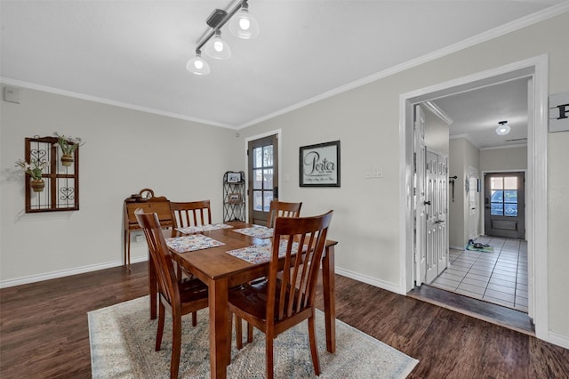 dining room with wood finished floors, baseboards, and ornamental molding
