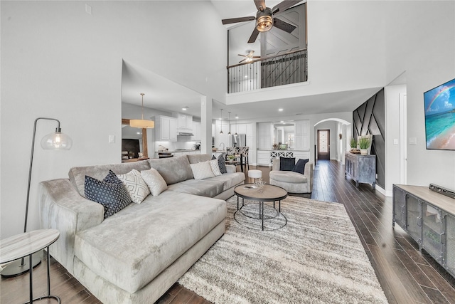846 Underwood Ln, Celina, TX 75009 - living area with arched walkways, a ceiling fan, dark wood finished floors, a high ceiling, and baseboards