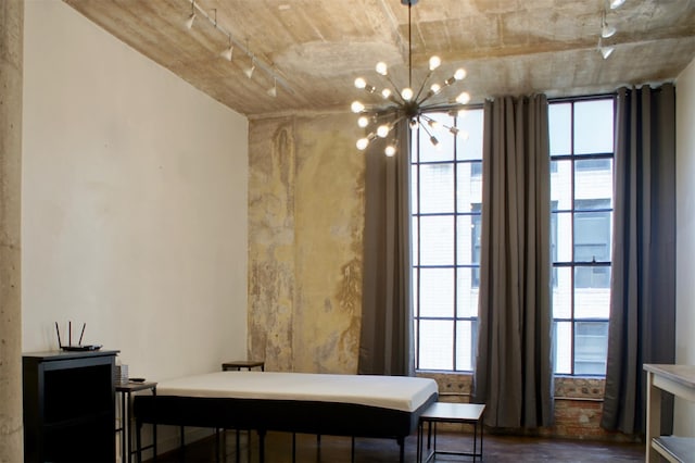 dining area featuring an inviting chandelier, track lighting, and dark wood finished floors