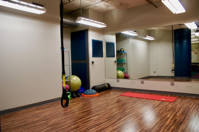 workout room with visible vents, baseboards, and wood finished floors