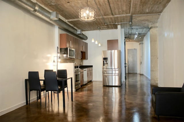 kitchen featuring a high ceiling, a sink, stainless steel appliances, and baseboards