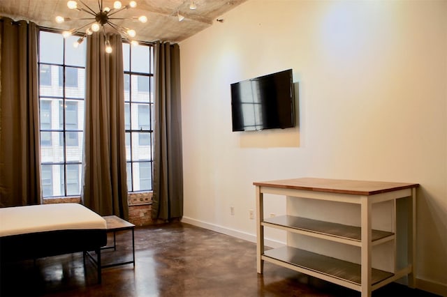 interior space with baseboards, concrete floors, an inviting chandelier, and expansive windows
