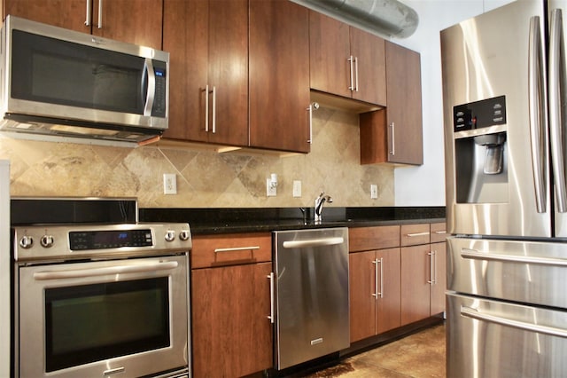 kitchen featuring dark stone counters, decorative backsplash, and stainless steel appliances