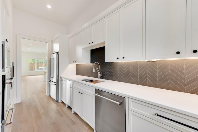 10519 Somerton Dr, Dallas, TX 75229 - kitchen featuring light countertops, white cabinetry, appliances with stainless steel finishes, and a sink