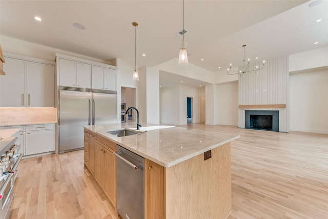 10519 Somerton Dr, Dallas, TX 75229 - kitchen featuring premium appliances, a center island with sink, a sink, and light wood finished floors