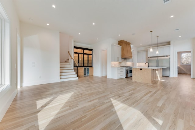 10519 Somerton Dr, Dallas, TX 75229 - unfurnished living room with light wood-type flooring, recessed lighting, baseboards, and stairway