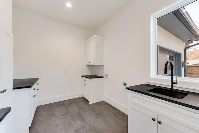 10519 Somerton Dr, Dallas, TX 75229 - washroom featuring baseboards, recessed lighting, electric dryer hookup, a sink, and cabinet space