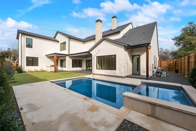 10519 Somerton Dr, Dallas, TX 75229 - back of house with a lawn, a patio area, stucco siding, and a chimney
