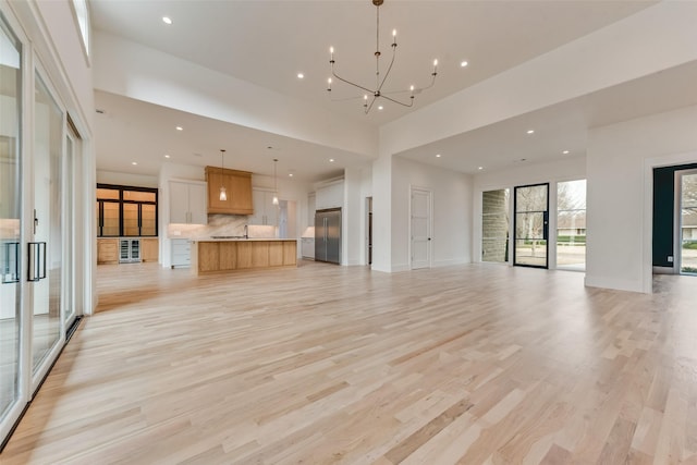 10519 Somerton Dr, Dallas, TX 75229 - unfurnished living room with recessed lighting, baseboards, a chandelier, and light wood-style flooring