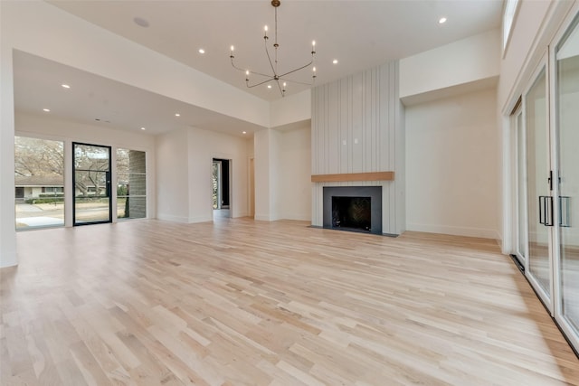 10519 Somerton Dr, Dallas, TX 75229 - unfurnished living room with a high ceiling, an inviting chandelier, a large fireplace, recessed lighting, and light wood-type flooring