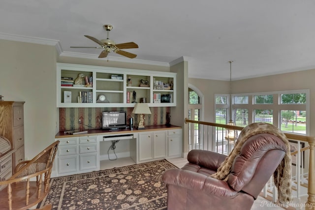 home office featuring ceiling fan, crown molding, and built in study area