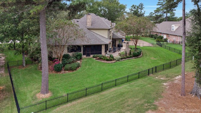 exterior space featuring a lawn, a patio, a fenced backyard, a sunroom, and a chimney