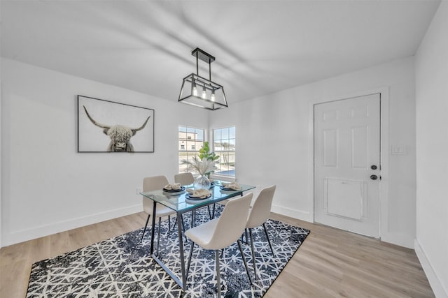 dining area with light wood-type flooring and baseboards