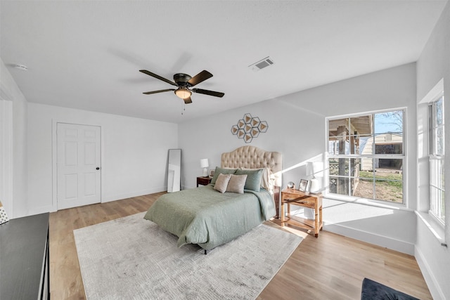 bedroom with light wood-style flooring, baseboards, and visible vents