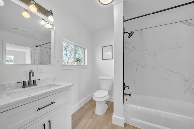 bathroom with visible vents, toilet, wood finished floors, washtub / shower combination, and vanity