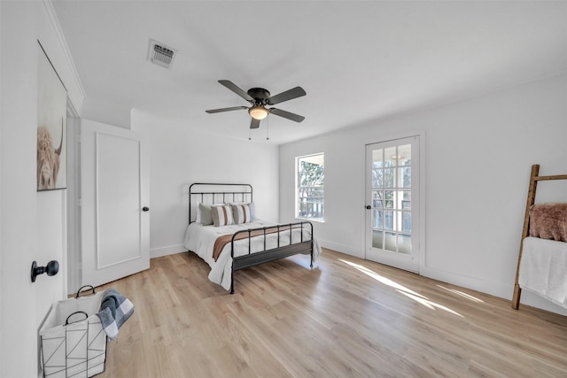 bedroom featuring visible vents, light wood-style flooring, a ceiling fan, and baseboards