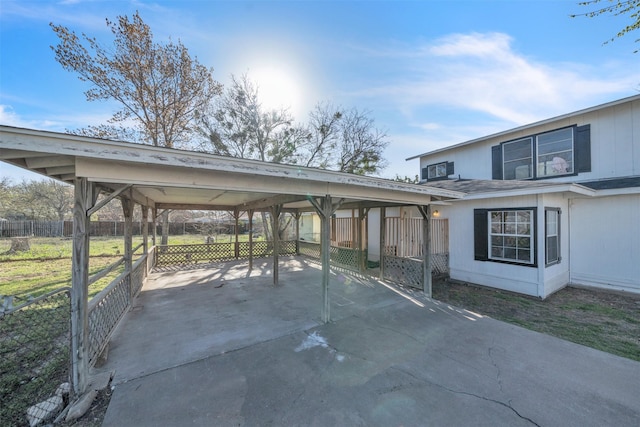 view of patio / terrace with an attached carport, driveway, and fence
