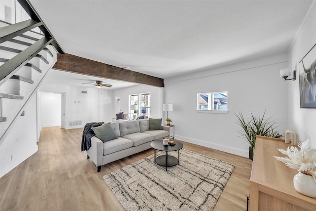 living area with stairway, plenty of natural light, light wood-style flooring, and baseboards