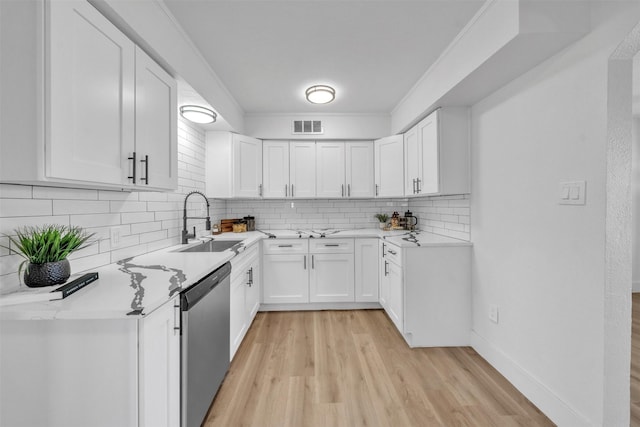 kitchen featuring visible vents, a sink, stainless steel dishwasher, crown molding, and light wood-type flooring