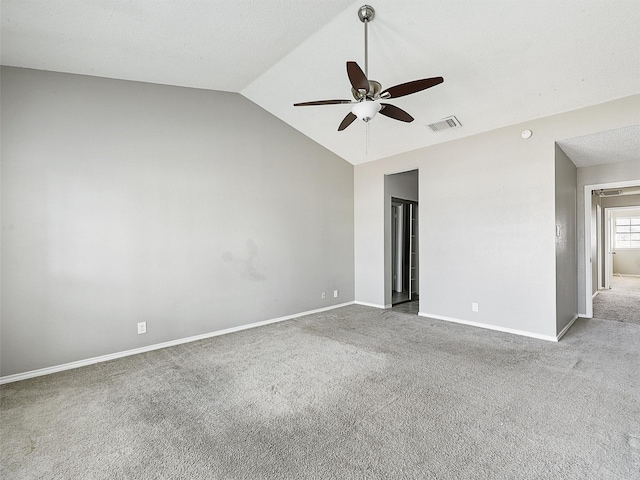 carpeted spare room featuring visible vents, baseboards, ceiling fan, and vaulted ceiling