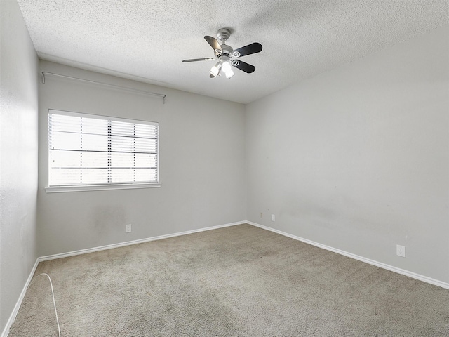 spare room with baseboards, carpet floors, a textured ceiling, and ceiling fan