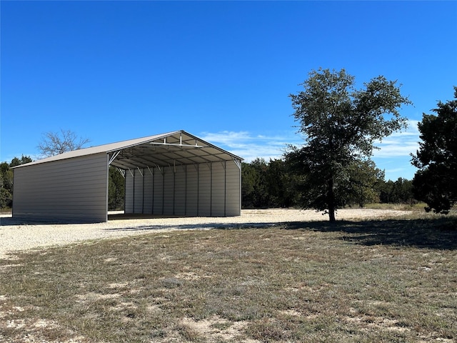 view of outdoor structure featuring a carport and driveway