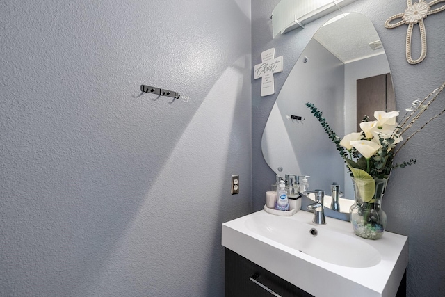 bathroom with vanity and a textured wall