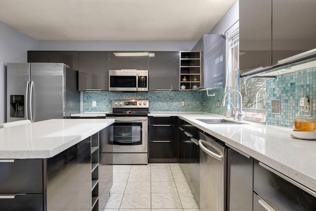 kitchen featuring modern cabinets, stainless steel appliances, a sink, open shelves, and backsplash