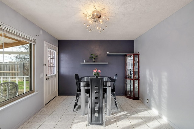 dining area featuring an inviting chandelier, baseboards, and a textured ceiling