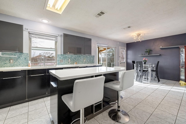kitchen with visible vents, light countertops, a sink, and a healthy amount of sunlight
