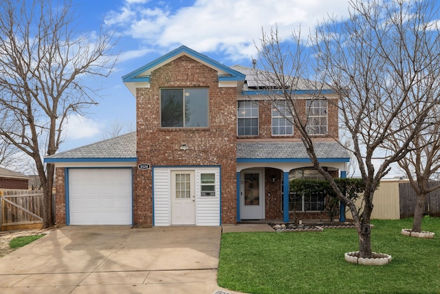 traditional home featuring fence, driveway, a front yard, brick siding, and a garage