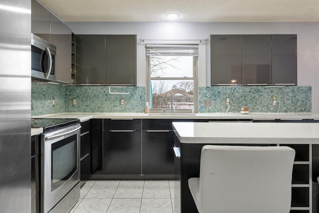 kitchen featuring gray cabinets, a sink, modern cabinets, and appliances with stainless steel finishes
