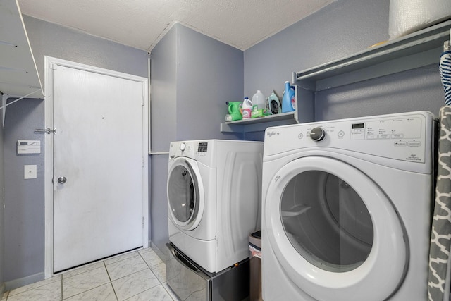 clothes washing area with a textured ceiling, laundry area, and washer and dryer