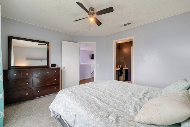 bedroom with visible vents, a ceiling fan, carpet floors, and a textured ceiling