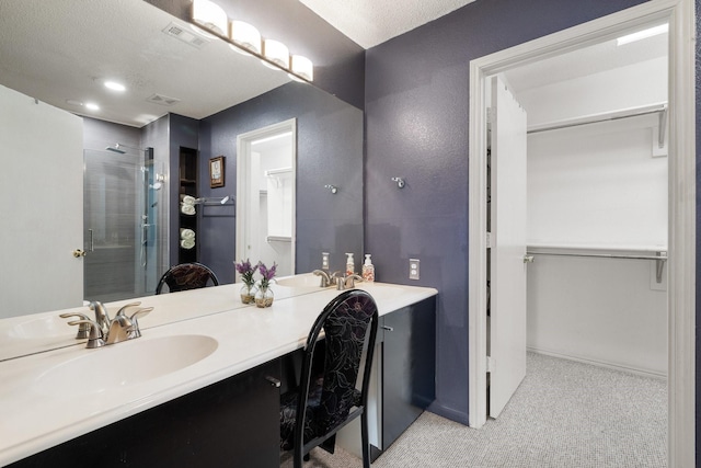 full bathroom featuring vanity, a walk in closet, and a stall shower
