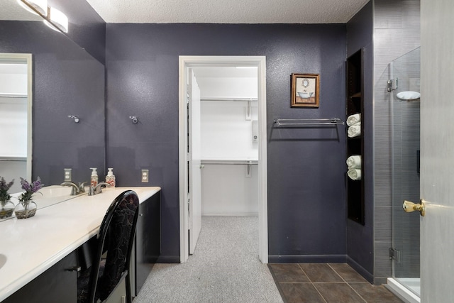 full bathroom featuring vanity, tile patterned flooring, a spacious closet, and a shower stall