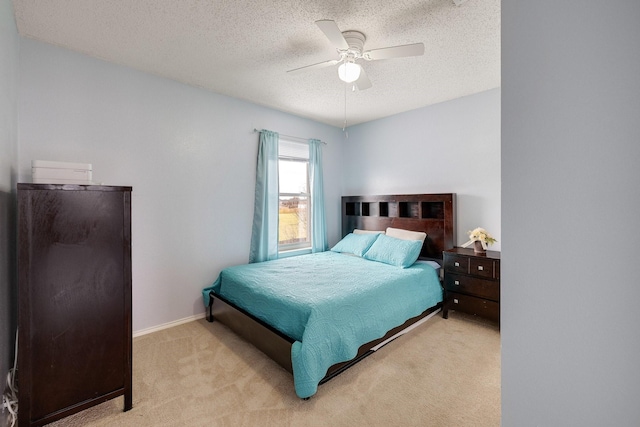 bedroom featuring baseboards, a textured ceiling, ceiling fan, and light colored carpet