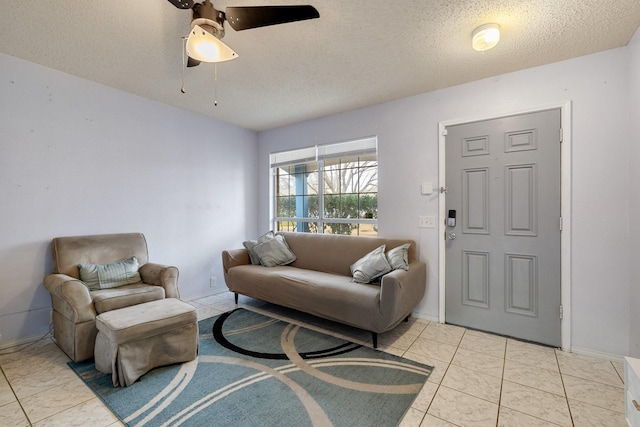 living area with a textured ceiling, tile patterned flooring, baseboards, and a ceiling fan