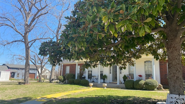 918 Wood St, Royse City, TX 75189 - obstructed view of property with covered porch, brick siding, and a front yard