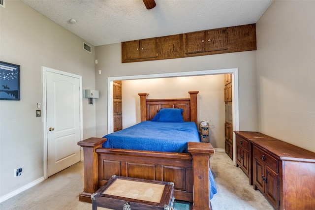bedroom with baseboards, light colored carpet, visible vents, and a textured ceiling