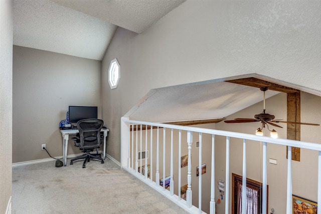 carpeted home office with baseboards, a textured ceiling, ceiling fan, and vaulted ceiling