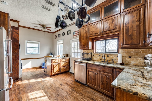 kitchen featuring visible vents, a sink, decorative backsplash, appliances with stainless steel finishes, and crown molding