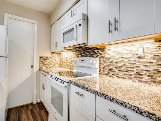 kitchen featuring light stone countertops, decorative backsplash, dark wood-style floors, white cabinets, and white appliances