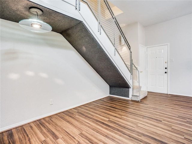 interior space with stairway, baseboards, and wood finished floors