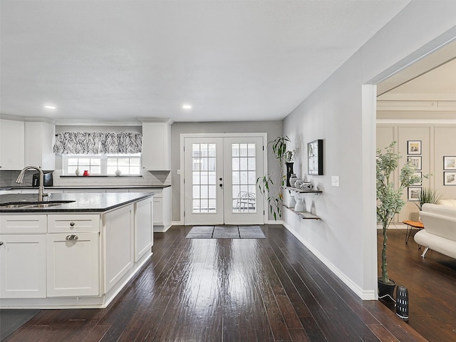 kitchen featuring a sink, french doors, dark wood-style flooring, dark stone countertops, and recessed lighting