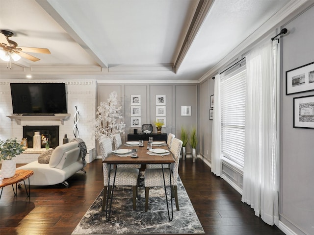 dining space with a ceiling fan, plenty of natural light, ornamental molding, a fireplace, and hardwood / wood-style floors