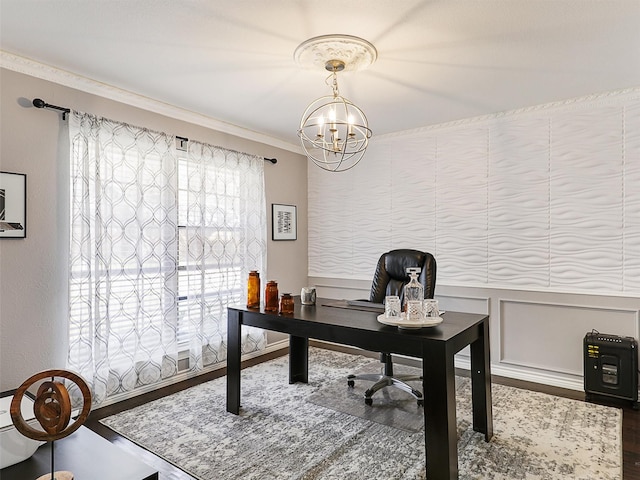 office space with a chandelier, wood finished floors, ornamental molding, and a wainscoted wall
